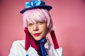 good looking chic female cosplayer in blue hat and vivid dress looking at camera on pink backdrop hoodie #699818086