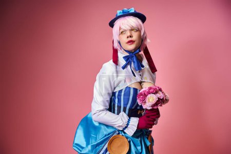 Téléchargez les photos : Séduisante cosplayer féminin en tenue vive tenant des fleurs roses et regardant loin sur fond rose - en image libre de droit