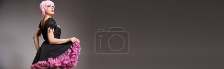 Photo for Appealing woman cosplaying anime character with pink hair and looking away on gray backdrop, banner - Royalty Free Image