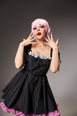 Photo for Appealing chic woman in black dress with pink hair cosplaying anime character and looking at camera - Royalty Free Image
