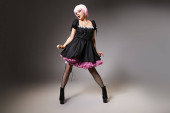 beautiful pink haired cosplayer in sexy maid costume posing on gray backdrop and looking away t-shirt #699819110