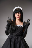 sexy woman in maid costume cosplaying and showing peace gesture and looking away on gray backdrop Tank Top #699819558