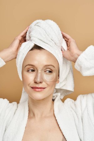 A woman with a towel wrapped around her head, exuding elegance and tranquility.
