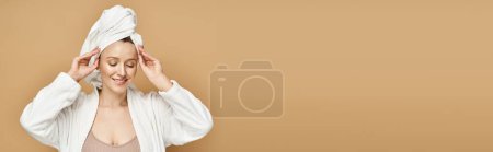 Foto de Una mujer atractiva con belleza natural, posando activamente con una toalla envuelta alrededor de su cabeza. - Imagen libre de derechos