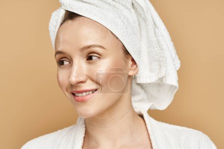 Téléchargez les photos : Une femme avec une serviette enroulée autour de sa tête, incarnant grâce et beauté naturelle dans un moment serein. - en image libre de droit