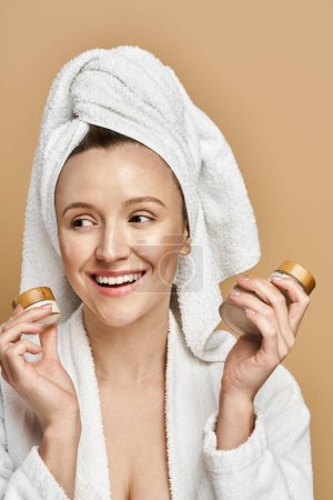 A natural beauty woman with a towel on her head holding two jars of cream, indulging in a skincare ritual.