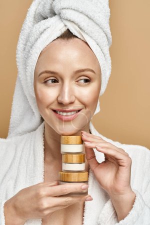 A woman with a towel on her head gracefully holds cream, embodying relaxation and elegance.