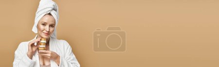 Photo for A graceful woman in a white robe holds cream, exuding natural beauty and elegance. - Royalty Free Image