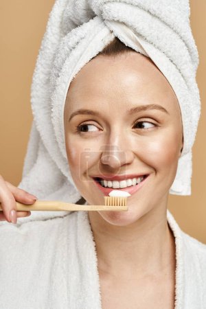 A natural beauty woman actively brushes her teeth while wearing a towel on her head.