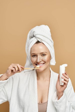 Eine Frau mit natürlicher Schönheit beim Zähneputzen, während sie ein Handtuch auf dem Kopf trägt.
