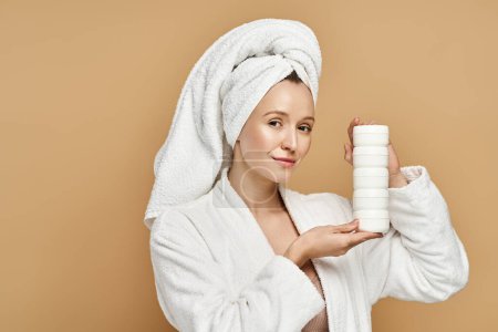 Una mujer vestida con una bata muestra su belleza natural mientras sostiene un tubo de crema.