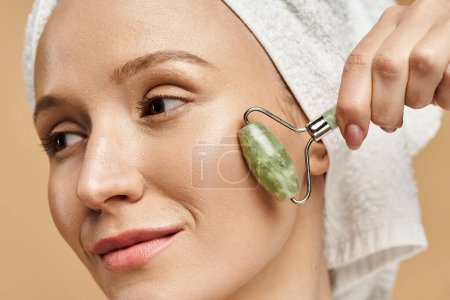 A beautiful woman with a towel on her head is playfully holding gua sha, showcasing natural beauty and creativity.