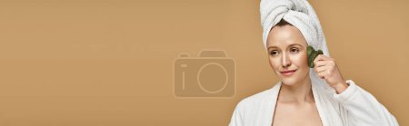 Photo for A natural beauty, an attractive woman poses gracefully with a towel wrapped around her head. - Royalty Free Image