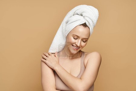 Una mujer elegante con una toalla en la cabeza, que encarna la belleza y el cuidado personal en un momento sereno.