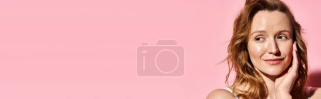Photo for A striking woman exudes elegance while posing gracefully in front of a vibrant pink background. - Royalty Free Image