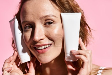 Una mujer con belleza natural sostiene un tubo de crema en su cara, aplicándolo con cuidado y atención.