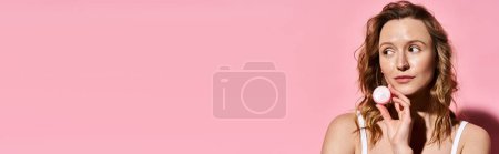 Photo for A stunning woman with natural beauty delicately holds a powder in front of her face, enhancing her features. - Royalty Free Image