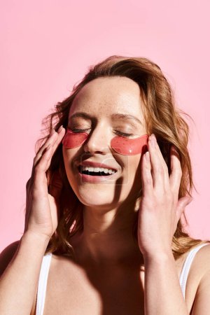 A woman with a pair of pink eye patches on her face, embodying self-care and relaxation.