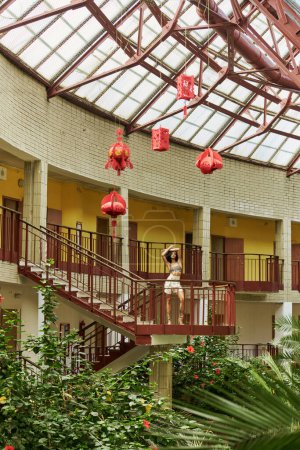 look from afar, african american woman in animal print, surrounded by greenery and red lanterns