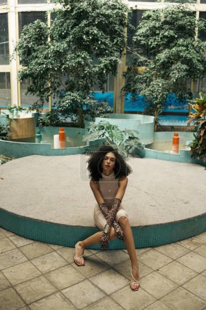 chic young african american woman in a botanical garden, embodying elegance and diversity
