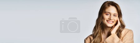 Téléchargez les photos : Jolie femme en veste beige avec des bijoux visage en forme de larme sur fond gris. Peach fuzz bannière - en image libre de droit