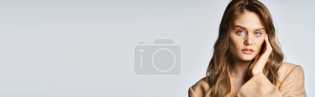 Téléchargez les photos : Portrait de jolie fille en veste beige avec des bijoux visage déchirure, regardant caméra, bannière - en image libre de droit