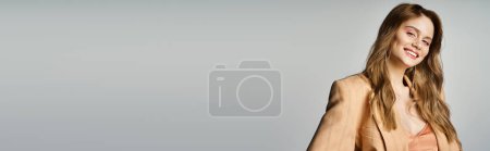 Foto de Chica alegre en chaqueta beige, usando maquillaje desnudo con joyas de la cara lágrima, sonriendo a la cámara, pancarta - Imagen libre de derechos