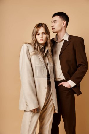 attraktiver junger Mann im Debonair-Anzug posiert neben seiner schönen Freundin, die in die Kamera schaut
