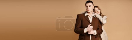 Photo for Young man in debonair suit posing next to his beautiful girlfriend who looking at camera, banner - Royalty Free Image