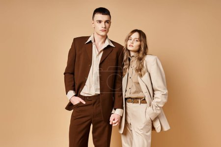 Photo for Debonair young woman in stylish suit posing with her handsome boyfriend and looking at camera - Royalty Free Image