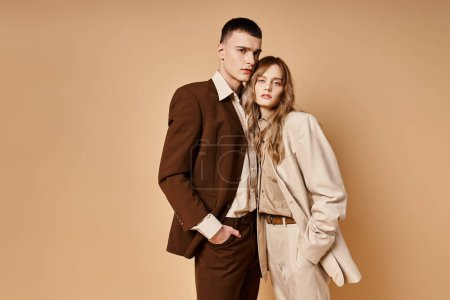 Photo for Attractive young woman in stylish suit posing with her handsome boyfriend and looking at camera - Royalty Free Image