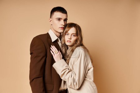 attractive young woman in stylish suit posing with her handsome boyfriend and looking at camera