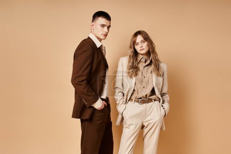Photo for Loving elegant boyfriend and girlfriend in chic suits looking at camera on pastel background - Royalty Free Image
