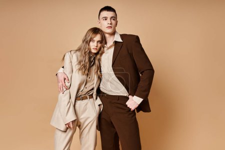 Photo for Sophisticated young woman in stylish suit posing with her handsome boyfriend and looking at camera - Royalty Free Image