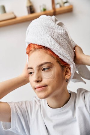 Photo for Attractive extravagant person with white hair towel sitting on her bed at home, morning routine - Royalty Free Image