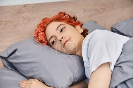 Foto de Extravagante bastante queer persona en traje casual despertar y estiramiento en su cama, tiempo libre - Imagen libre de derechos