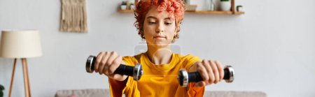 Photo for Good looking queer person in vibrant sport attire exercising with dumbbells while at home, banner - Royalty Free Image
