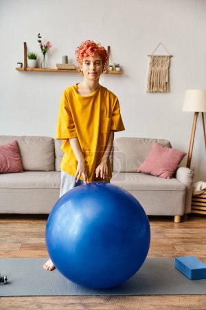 Photo for Joyful extravagant person in comfy attire exercising with fitness ball and smiling at camera - Royalty Free Image