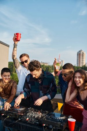 diverse cheerful people in vivid outfits partying together next to handsome DJ at rooftop party