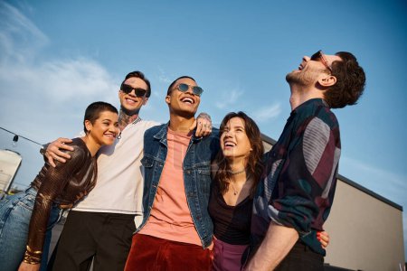cheerful multicultural friends with fashionable sunglasses having fun together at rooftop party