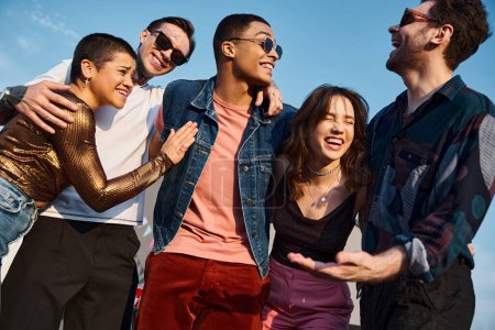 joyful multicultural friends with stylish sunglasses having much fun together at rooftop party