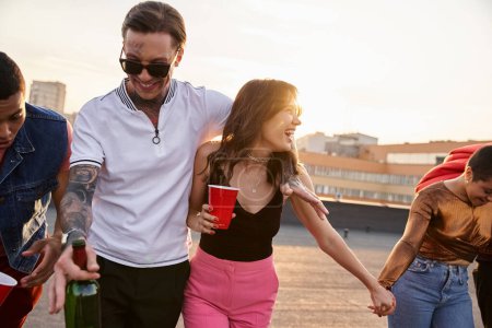 Betrunkene fröhliche Freunde in schwungvoller Kleidung mit Alkoholgetränken und Spaß auf Party