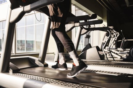 Photo for A man in active wear is running on a treadmill in a gym setting, with focused determination and a strong stride. - Royalty Free Image