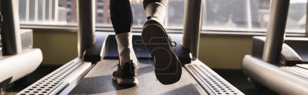 Photo for An athletic man in active wear walking on a treadmill in a gym. - Royalty Free Image