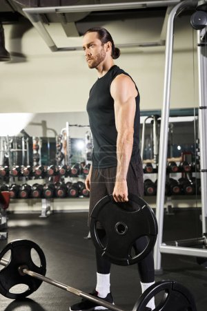 Athletischer Mann im Fitnessstudio mit einer Langhantel, der während der Trainingseinheit Stärke und Entschlossenheit zeigt.