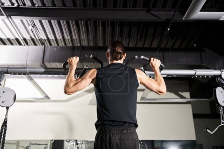 Foto de Un hombre en un gimnasio, vestido con ropa deportiva, levanta un bar ponderado durante su rutina de entrenamiento. - Imagen libre de derechos