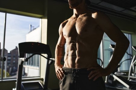 Photo for A shirtless man showcases his strength in front of a gym machine, focused and determined. - Royalty Free Image