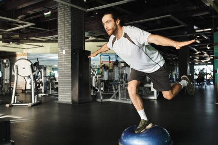 Un hombre musculoso realiza creativamente ejercicios en una pelota de ejercicio en un gimnasio.