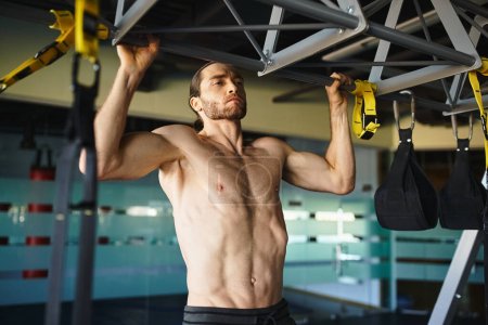 Shirtless muscular man grips gym equipment, focusing on strength and fitness training.