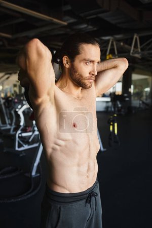 A shirtless and muscular sportsman working out in a gym.